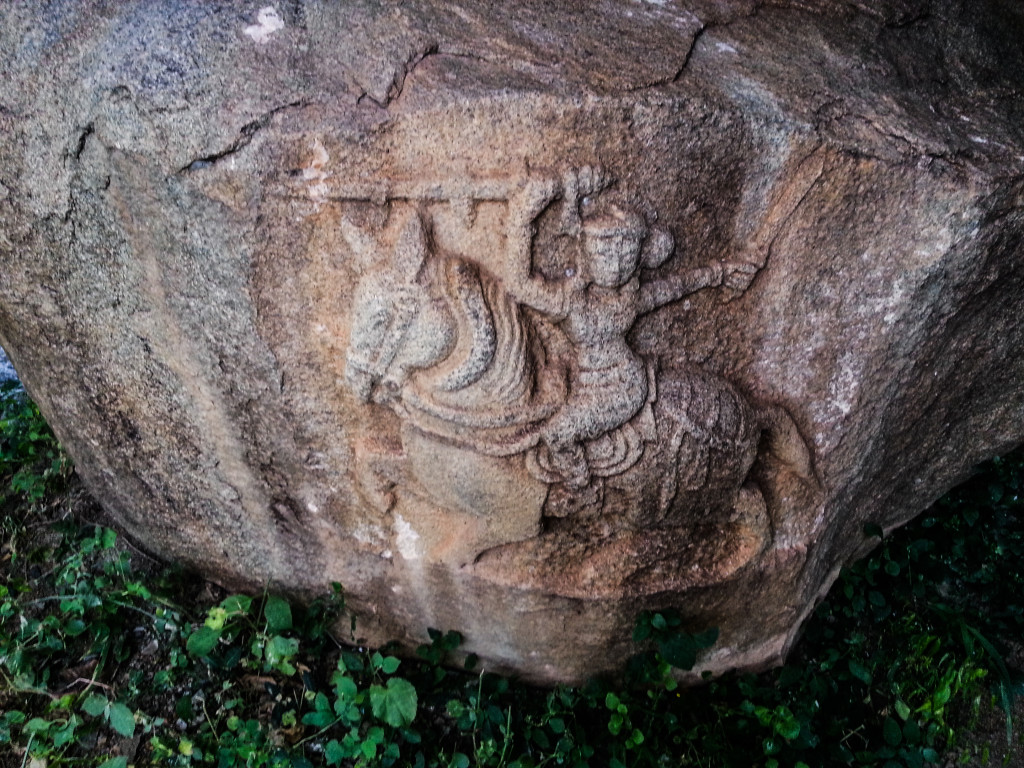 Rock relief sculpture on a boulder wall at entrance of the cave